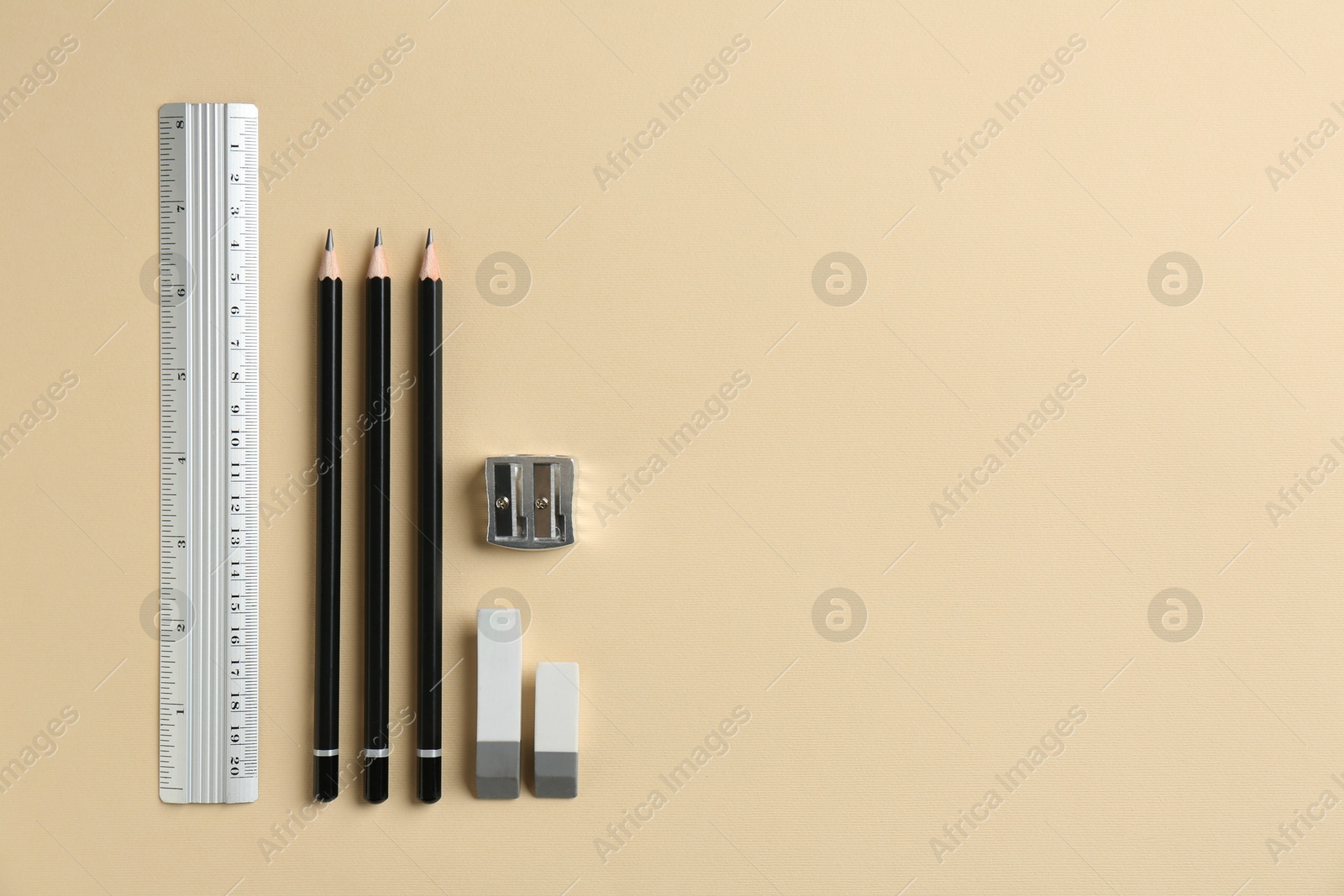 Photo of Flat lay composition with ruler and other stationery on beige background, space for text