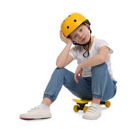 Photo of Little girl in helmet sitting on penny board against white background