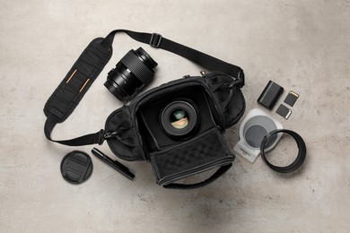 Photo of Professional photographer's equipment and case on light background, flat lay