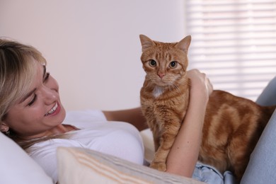 Photo of Woman with cute ginger cat at home