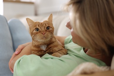 Photo of Woman with her cute ginger cat at home