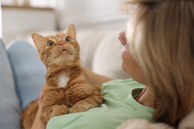 Photo of Woman with her cute ginger cat at home