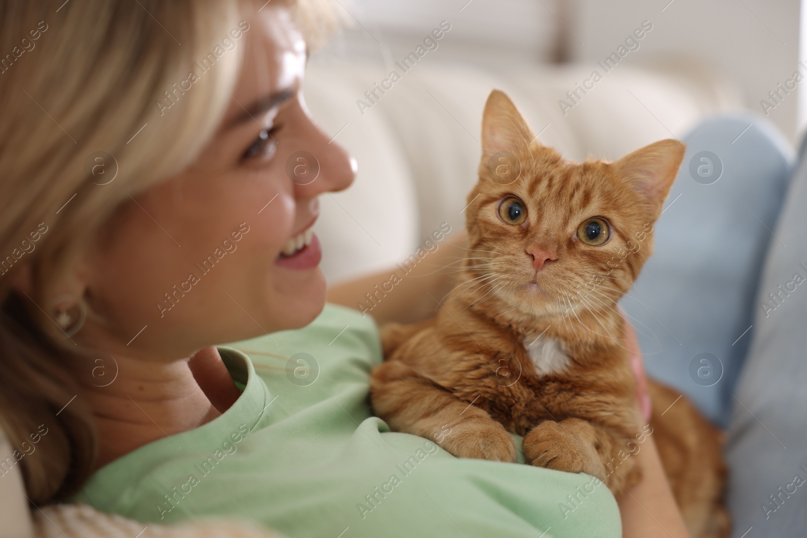 Photo of Woman with her cute ginger cat at home