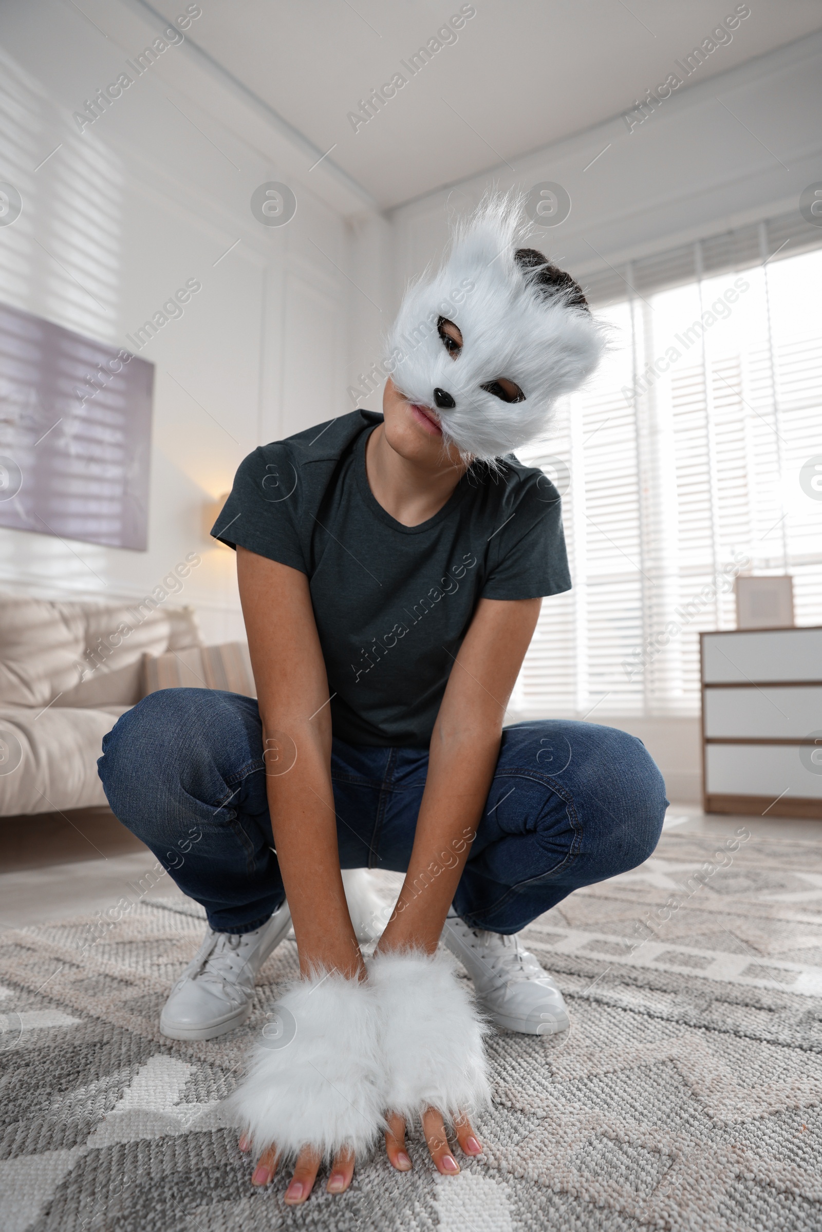 Photo of Quadrobics. Boy wearing cat mask and gloves at home