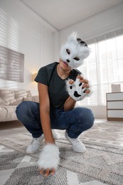 Photo of Quadrobics. Boy wearing cat mask and gloves at home