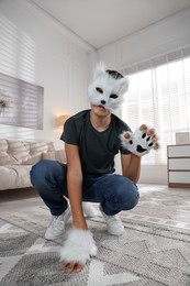 Photo of Quadrobics. Boy wearing cat mask and gloves at home