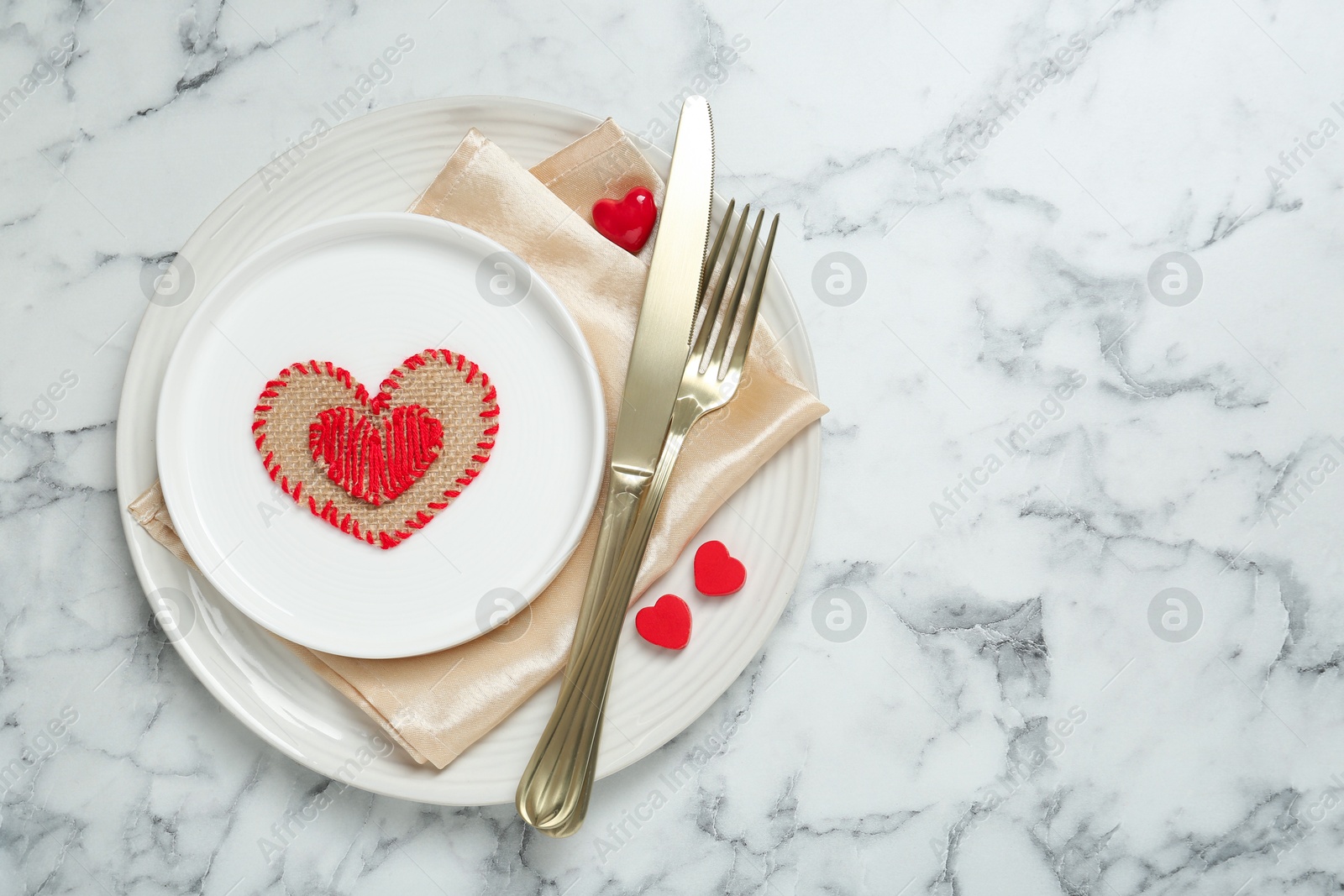 Photo of Romantic place setting for Valentine's day. Tableware, cutlery and decorative hearts on white marble table, top view. Space for text