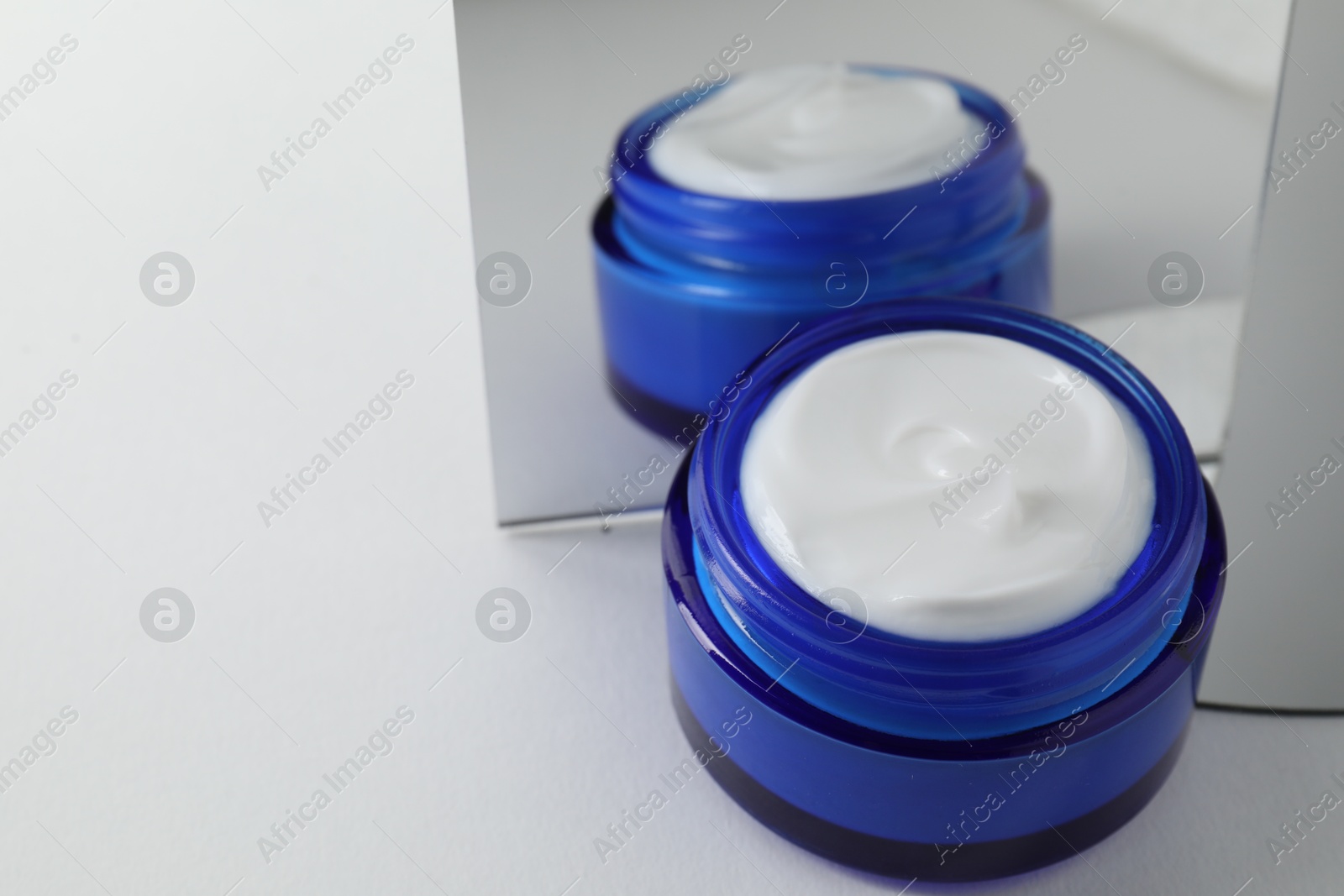 Photo of Stylish presentation of facial cream on light background, closeup. Space for text