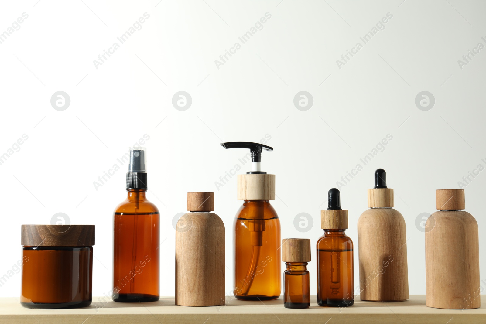 Photo of Different cosmetic products on wooden table against white background, space for text