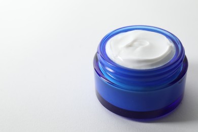 Photo of Jar of cream on white background, closeup. Space for text