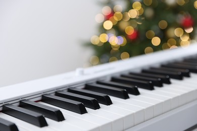 Photo of Electronic synthesizer against Christmas lights, closeup. Bokeh effect