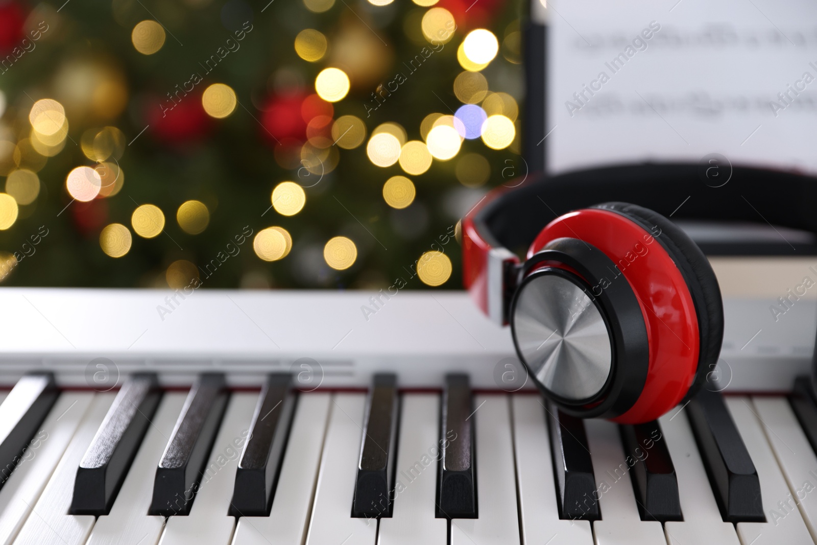 Synthesizer with headphones against blurred Christmas lights, closeup. Bokeh effect Photo of Synthesizer with headphones against blurred Christmas lights, closeup. Bokeh effect