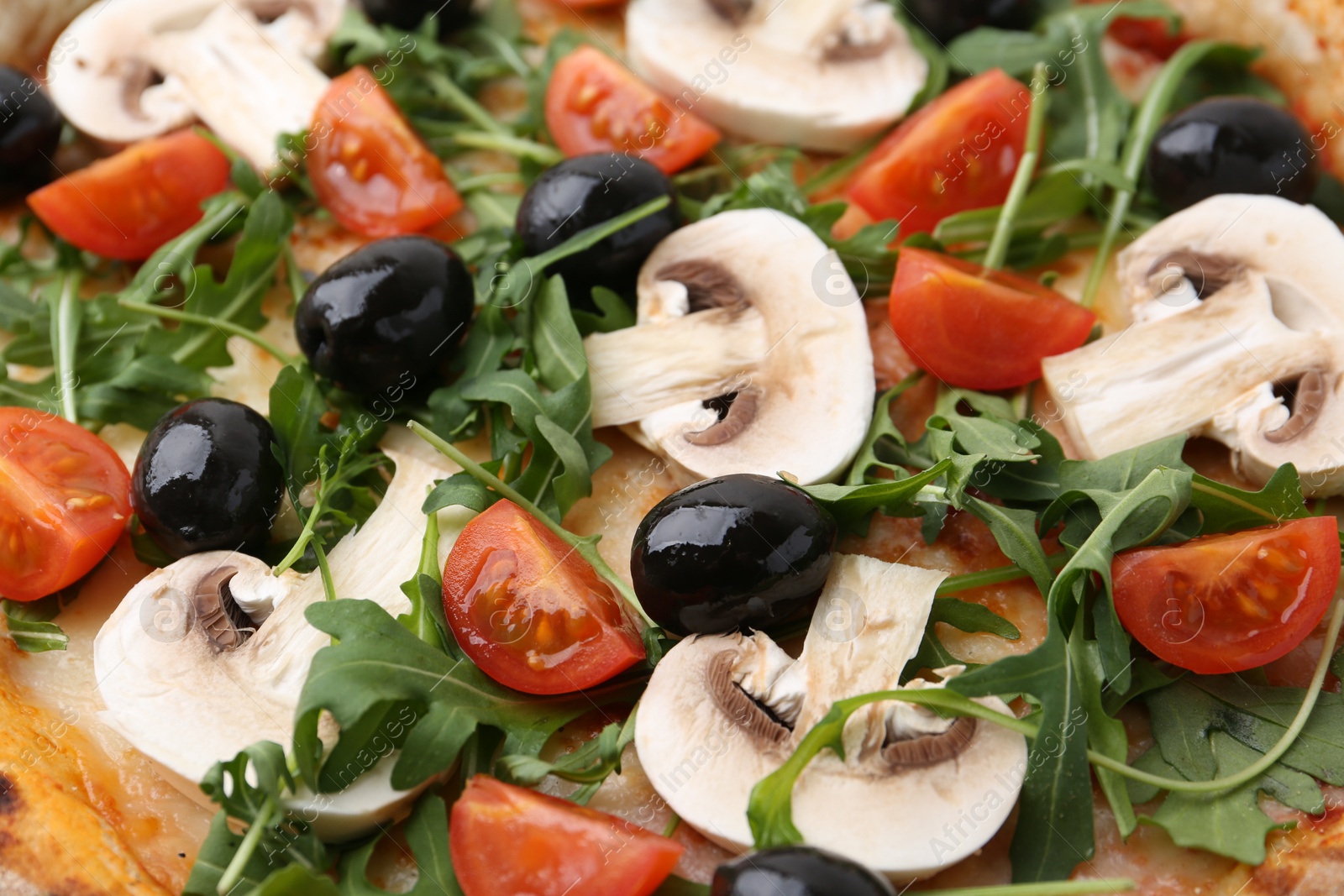 Photo of Tasty pizza with cherry tomatoes, black olives, mushrooms and arugula as background, closeup