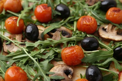 Photo of Tasty pizza with cherry tomatoes, black olives, mushrooms and arugula as background, closeup