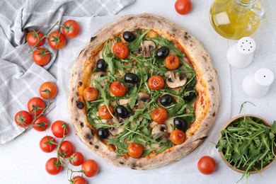 Photo of Tasty pizza with cherry tomatoes, black olives, mushrooms and arugula on white table, flat lay