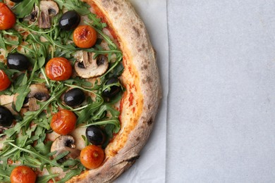 Photo of Tasty pizza with cherry tomatoes, black olives, mushrooms and arugula on light grey table, top view. Space for text