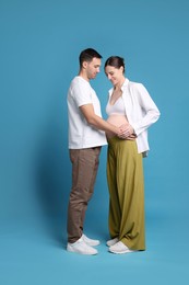 Photo of Pregnant woman and her husband on blue background