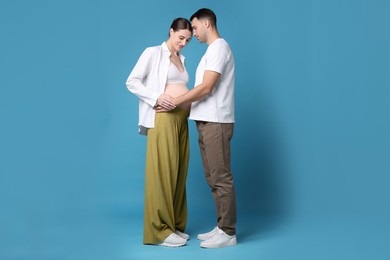 Photo of Pregnant woman and her husband on blue background