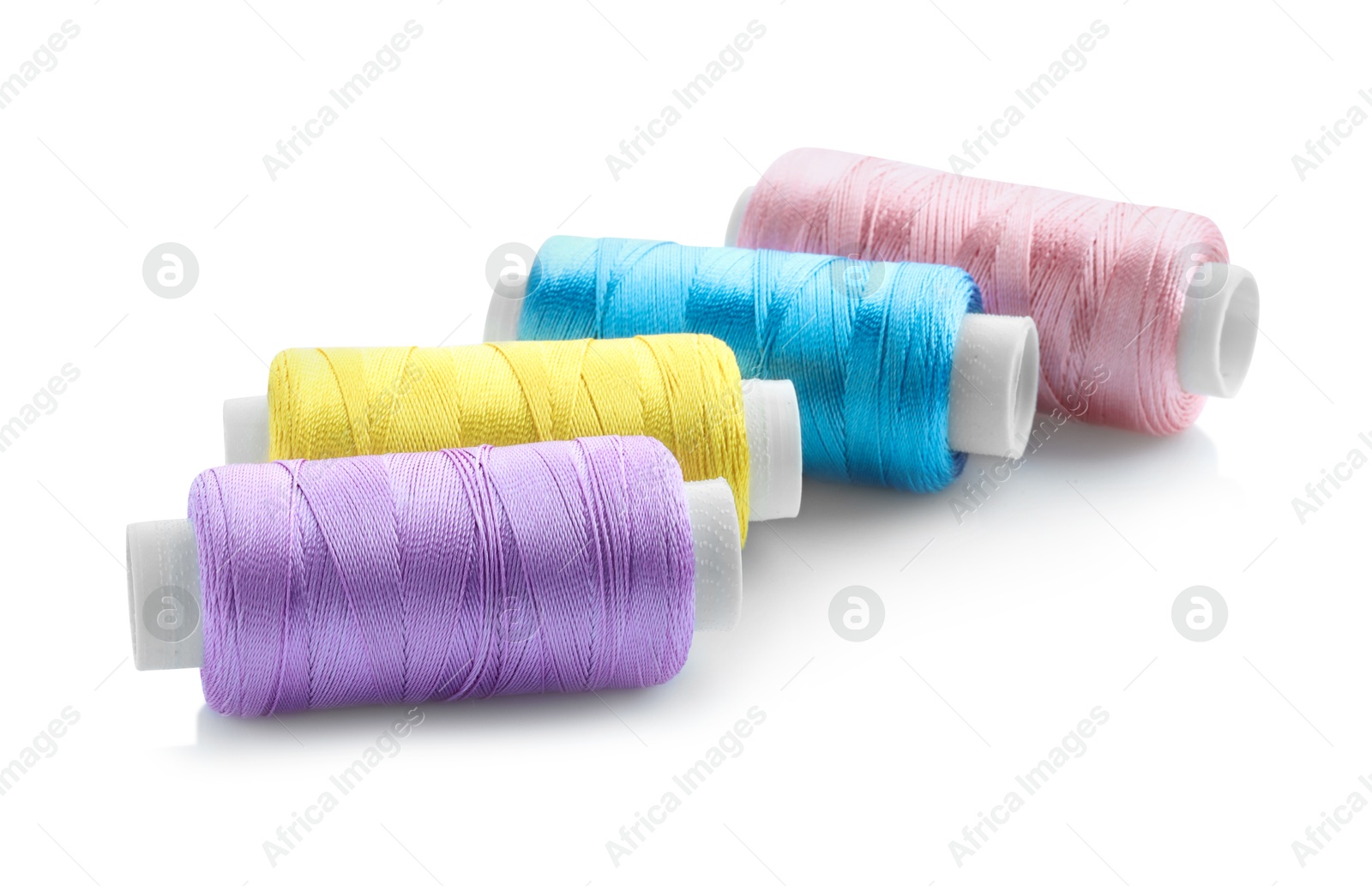 Photo of Spools of bright sewing threads isolated on white