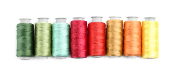 Photo of Spools of bright sewing threads isolated on white, top view