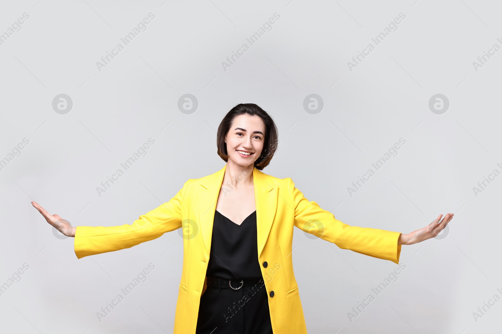 Photo of Happy businesswoman welcoming clients or partners on light grey background