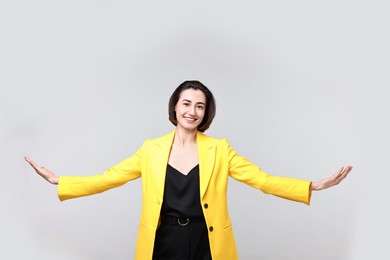 Photo of Happy businesswoman welcoming clients or partners on light grey background