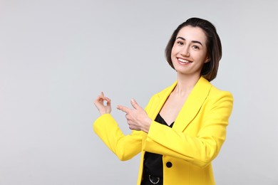 Photo of Happy businesswoman welcoming clients or partners on light grey background