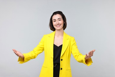 Photo of Happy businesswoman welcoming clients or partners on light grey background