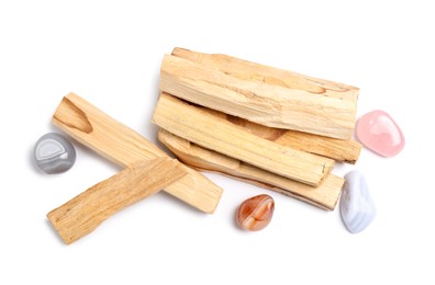 Photo of Palo santo sticks and gemstones isolated on white, top view