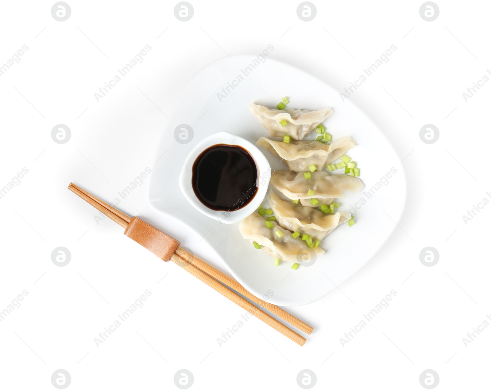 Photo of Tasty gyoza (dumplings), soy sauce and chopsticks isolated on white, top view