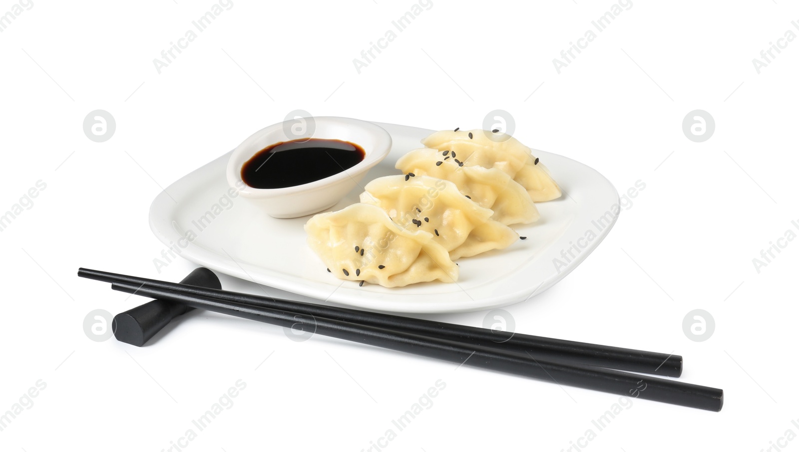 Photo of Tasty gyoza (dumplings), soy sauce and chopsticks isolated on white