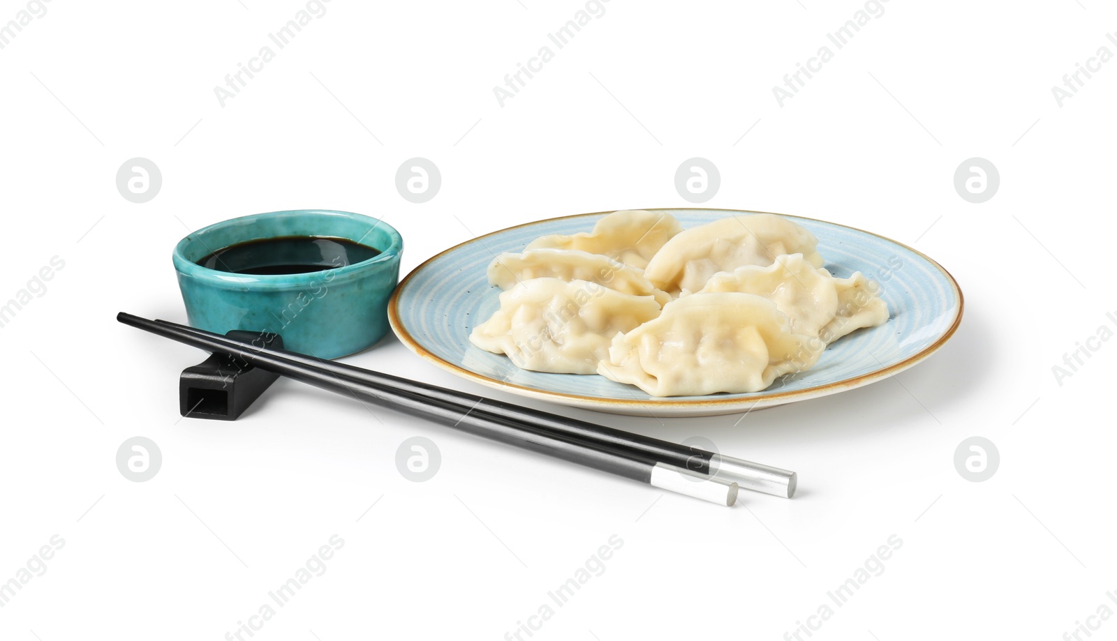 Photo of Tasty gyoza (dumplings), soy sauce and chopsticks isolated on white