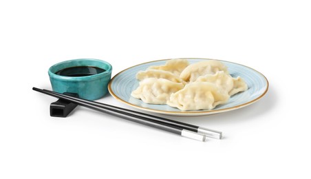 Photo of Tasty gyoza (dumplings), soy sauce and chopsticks isolated on white