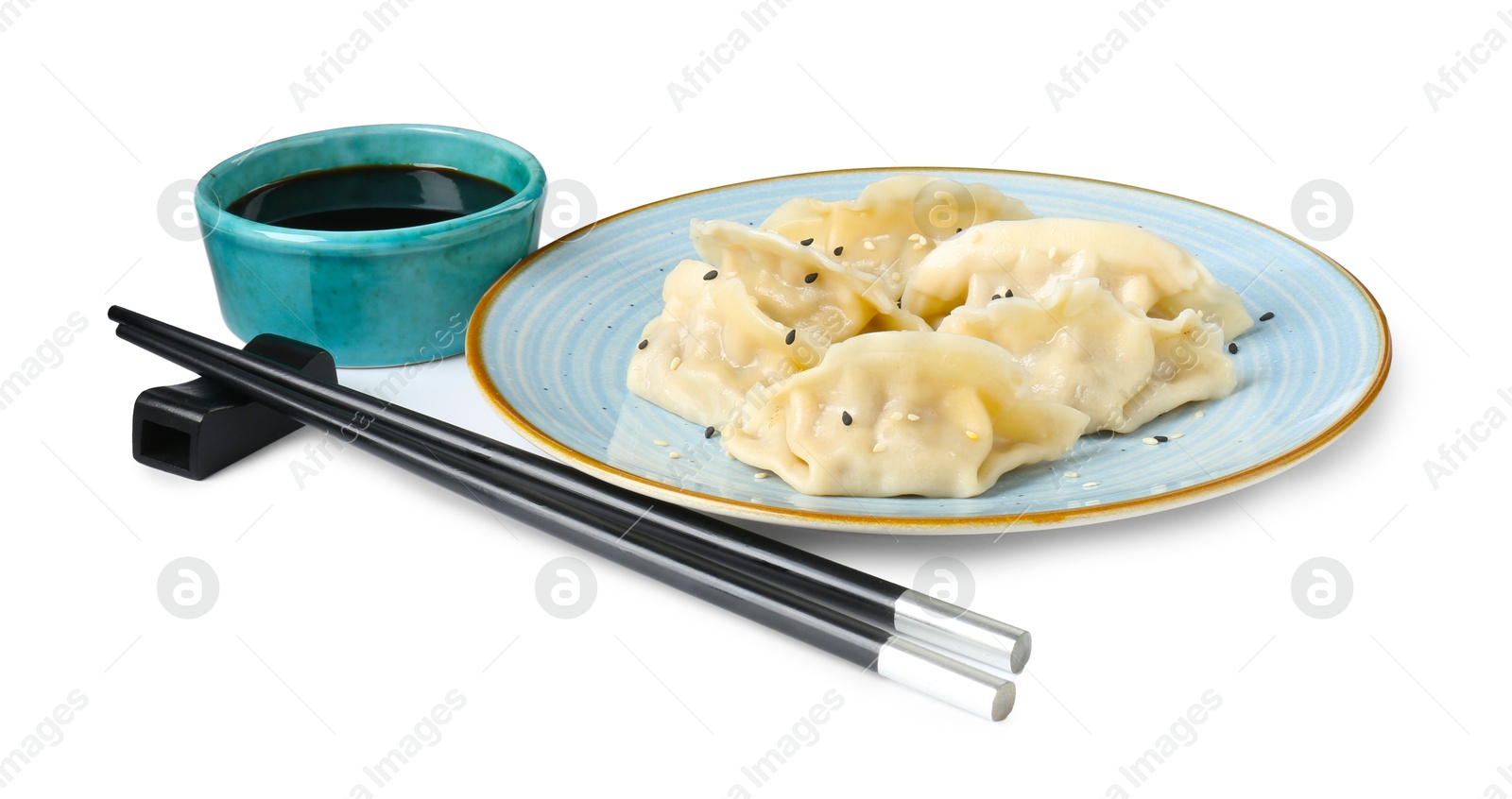 Photo of Tasty gyoza (dumplings), soy sauce and chopsticks isolated on white