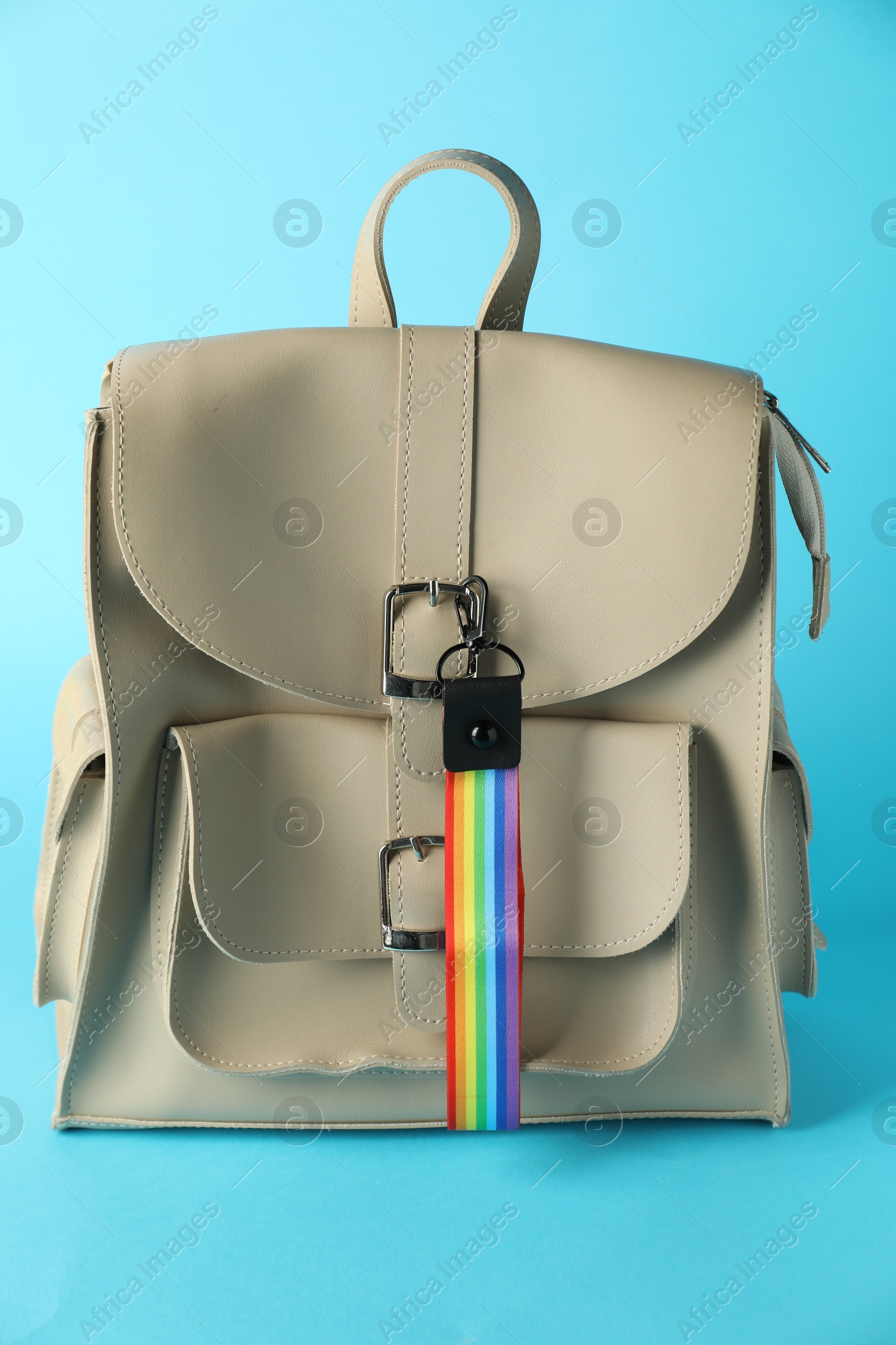 Photo of Backpack with keychain in LGBT colors on light blue background