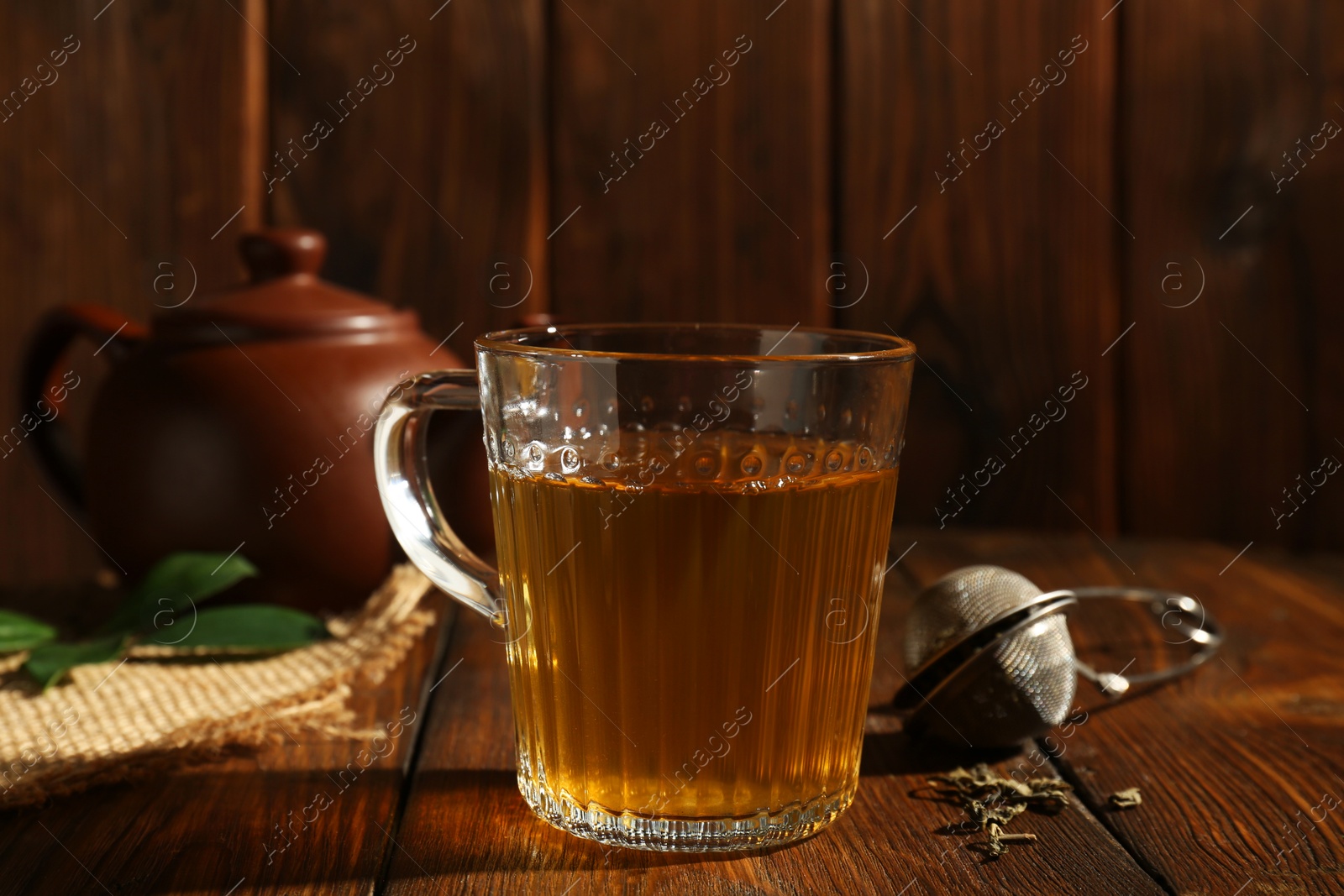 Photo of Refreshing green tea in cup on wooden table, closeup