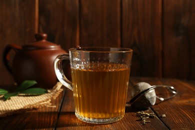 Photo of Refreshing green tea in cup on wooden table, closeup