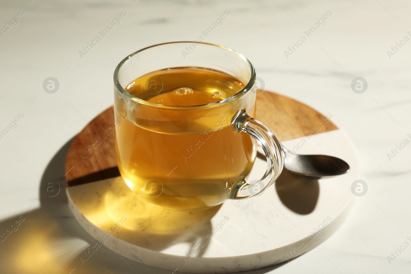 Photo of Refreshing green tea in cup on white marble table, closeup