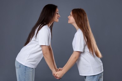 Photo of Beautiful mother with teenage daughter on grey background