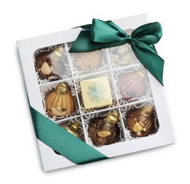 Photo of Gift box with delicious chocolate in shape of Christmas ornaments isolated on white, top view