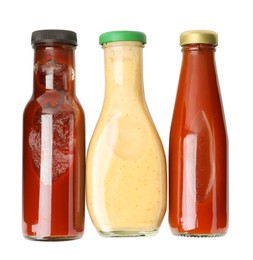 Photo of Different delicious sauces in glass bottles isolated on white, top view