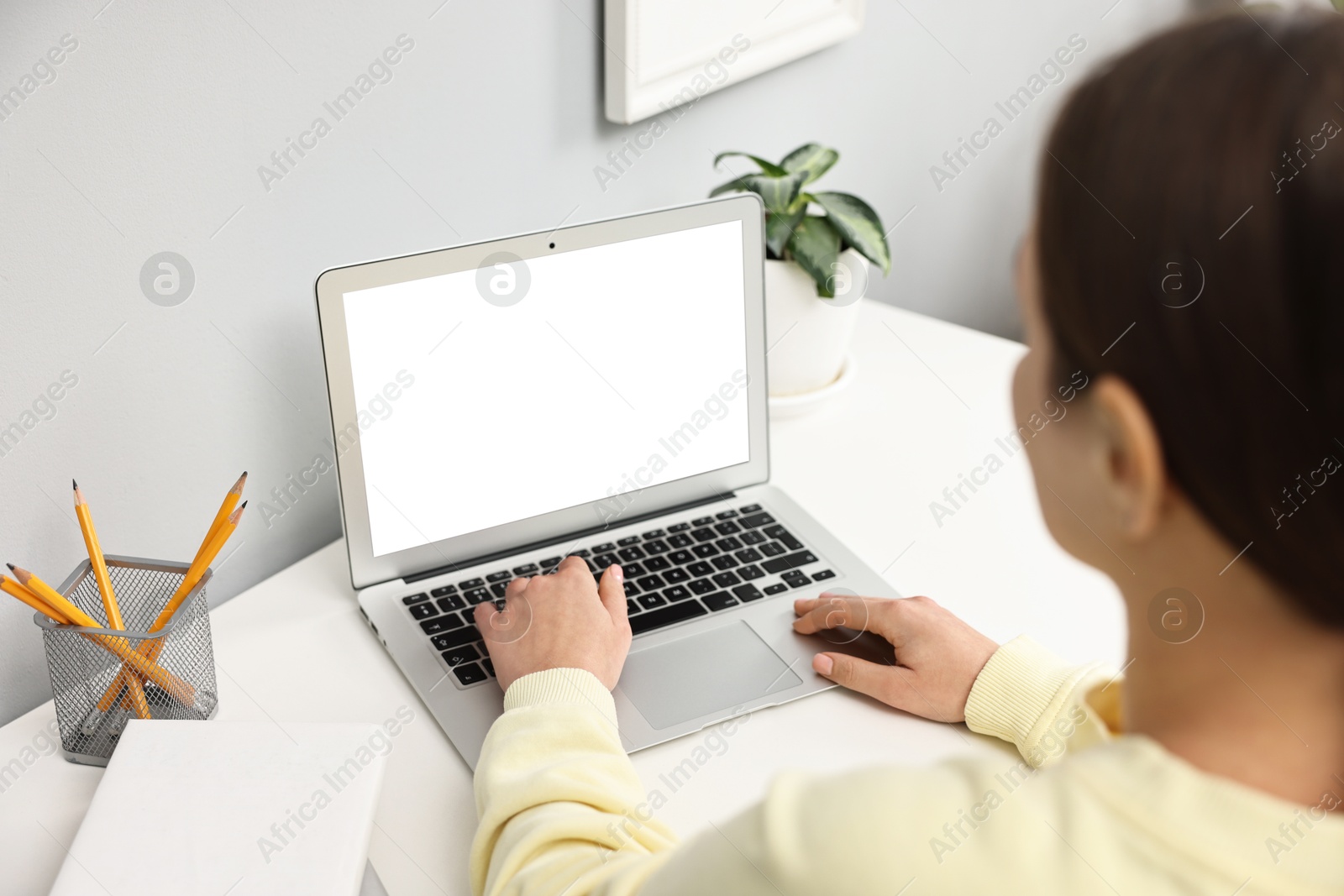 Photo of Woman working on computer at desk indoors, closeup