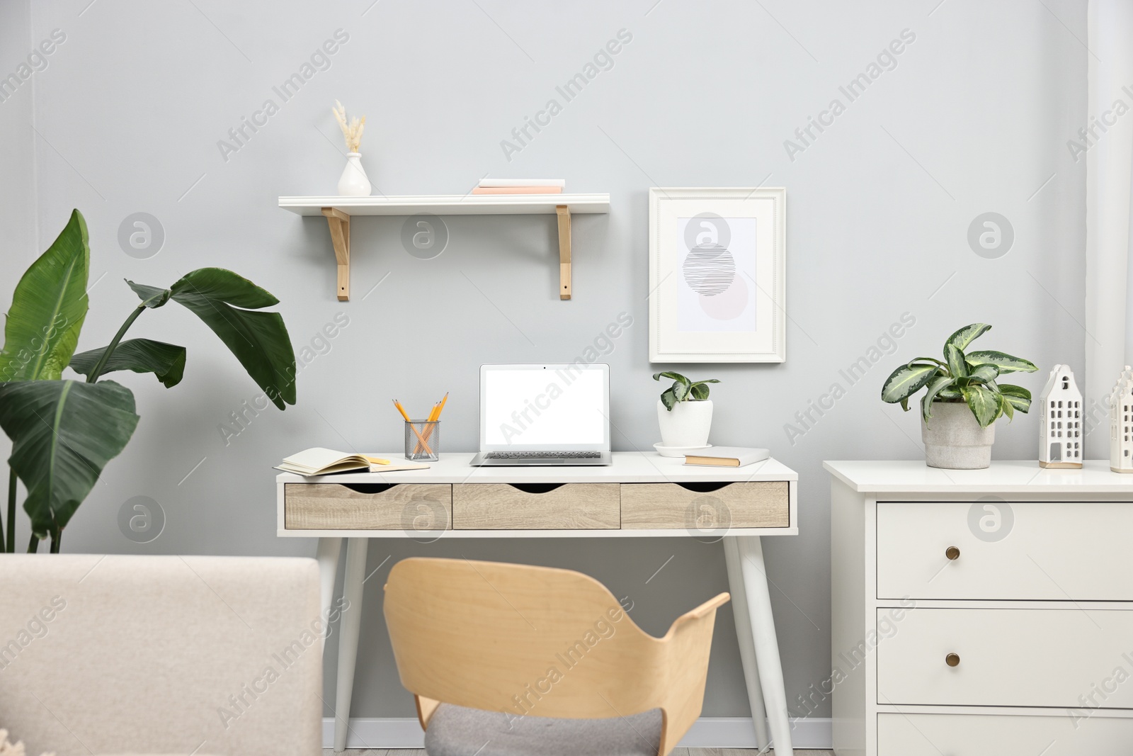 Photo of Comfortable workplace with modern laptop on white table indoors