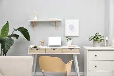 Photo of Comfortable workplace with modern laptop on white table indoors