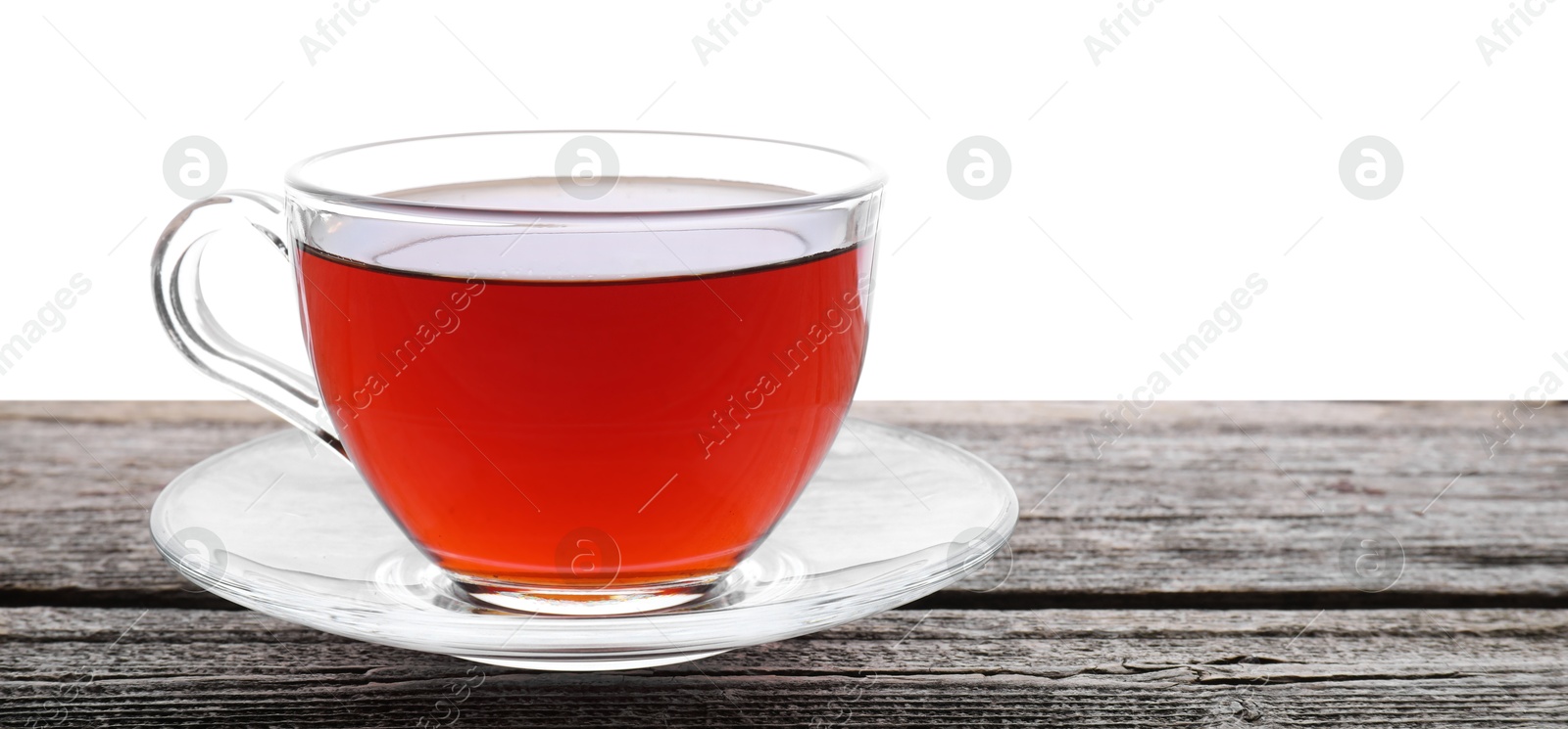 Photo of Refreshing black tea in cup on wooden table against white background