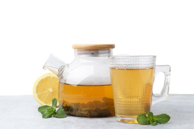 Photo of Aromatic mint tea, fresh leaves and lemon on light gray table against white background