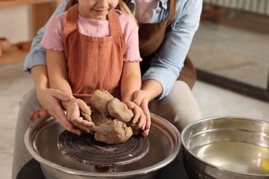 Photo of Hobby and craft. Mother with her daughter making pottery indoors, closeup