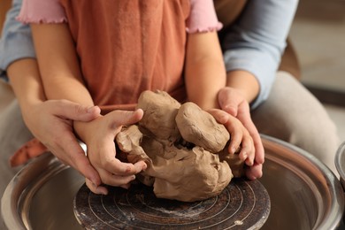 Photo of Hobby and craft. Mother with her daughter making pottery indoors, closeup