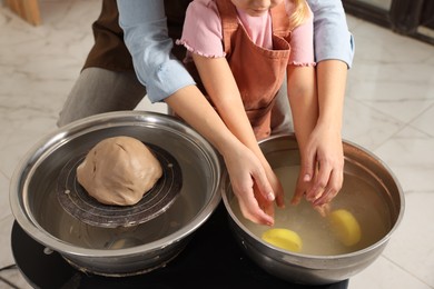 Photo of Hobby and craft. Mother with her daughter making pottery indoors, closeup