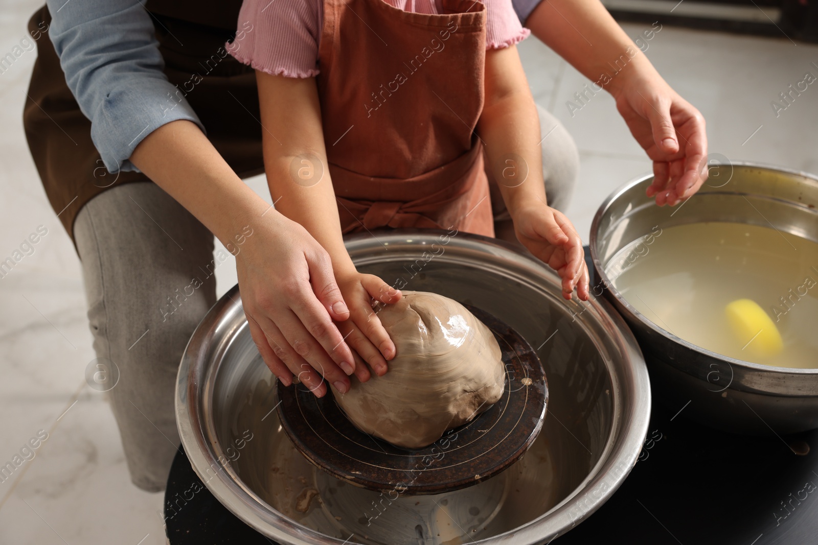 Photo of Hobby and craft. Mother with her daughter making pottery indoors, closeup